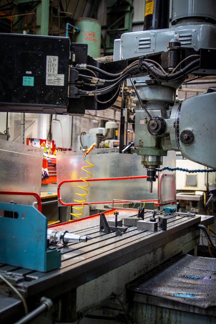 Close-up of an industrial CNC lathe in a bustling machine shop setting, focused on precision metalwork.